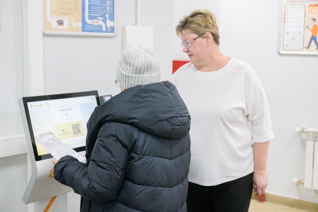 Сотрудница МосОблЕИРЦ помогает жительнице передать показания через терминал